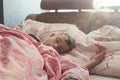 the boy sleeps in a pink bed in a sound morning sleep under the sun& x27;s rays