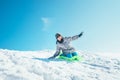 Boy slides down from the snow slope. Enjoying the winter sledding time