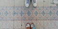 boy with slippers and girl with sandals on pink colored tile Royalty Free Stock Photo