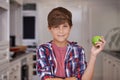 Boy, smile and portrait in kitchen with apple for nutrition, breakfast and health in house for snack. Child or kid in Royalty Free Stock Photo