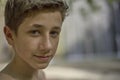 Closeup of a handsome self-confident young teenager in summer relaxed happy mood on his face