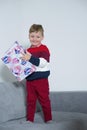 Boy smiles while holding a big gift in his hands Royalty Free Stock Photo