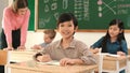 Boy smiling to camera while student writing answer in answer sheet. Pedagogy. Royalty Free Stock Photo