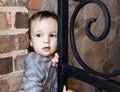 Curious Boy Sneaking out of Gate to House Royalty Free Stock Photo