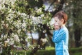 Boy sneezes in the park against the background of a flowering tree because he is allergic Royalty Free Stock Photo