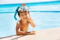 Boy with snorkel mask on head and pointing finger