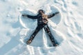 The boy on a snow flapping arms and legs angel shows Royalty Free Stock Photo