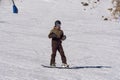 Boy with Snowboard With protective Helmet and Ski Mask having Fun on a Snowy Ski Slope in the Italian Dolomites Mountains