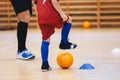 Boy in Soccer Clothes with Orange Futsal Ball. Kid on indoor soccer training with a coach