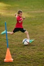 Boy soccer player in red sport uniform training kicking ball, prepare to match on football field in motion. Playing Royalty Free Stock Photo