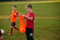 Boy soccer player wearing bright orange sport uniform on match on football field in motion. Playing football Royalty Free Stock Photo