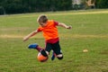 Boy soccer player wearing sport uniform on match on football field showing freestyle, feints in motion. Playing Royalty Free Stock Photo