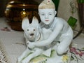 A boy in a soldier`s cap with a German shepherd. Young border guard. Retro porcelain figurine of a boy and a dog, collection.