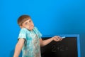 The boy solves the math equation 2 + 2 written on the blackboard. The child does not know the answer to simple examples Royalty Free Stock Photo