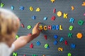 Boy spelling out the word school. Magnet letters Royalty Free Stock Photo