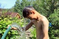 The boy with splash water in very hot summer day outdoors Royalty Free Stock Photo