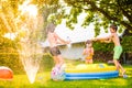 Boy splashing girls with water gun in the garden Royalty Free Stock Photo