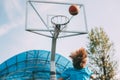 A boy in a sports uniform throws a ball into a basketball basket. A child plays basketball. Sports, lifestyle. Rear view