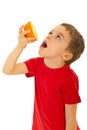 Boy squeeze orange to his mouth Royalty Free Stock Photo