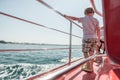 Boy standing on boat deck on sunny day Royalty Free Stock Photo