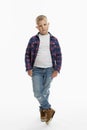 The boy is standing. A cute fat schoolboy in jeans, a shirt and a white T-shirt. Full height. White background. Vertical