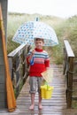 Boy standing on footbridge with umbrella Royalty Free Stock Photo