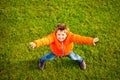 Boy standing on green grass with outstretched arms Royalty Free Stock Photo