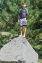 Boy Standing on a Large Rock by Pine Tree Royalty Free Stock Photo