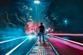 boy standing middle of the street -light trails in the street- light painting