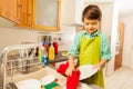 Boy standing next to the sink and wiping dry plate Royalty Free Stock Photo