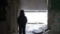 Boy is standing in an old ruined house, demolition old ramshackle building