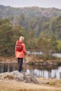 A boy standing on a rock admiring a view of lake, back view, Lake District, UK Royalty Free Stock Photo