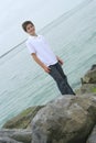 Boy standing on rocks at the beach Royalty Free Stock Photo