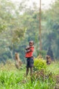 A boy standing in a rural landscape In Uganda.