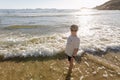 A boy standing in the shallows at the beach Royalty Free Stock Photo