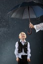 Boy standing under umbrella in rain