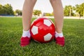 A boy stands on the football field of a stadium with a soccer ball between his legs. Children play football on the grass. Training Royalty Free Stock Photo