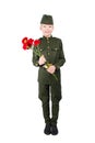 Boy stands in military uniform and cap, with carnations in hands