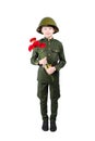 Boy stands in military uniform and helmet, with carnations in hands