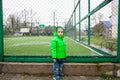 A boy stands near the football field.