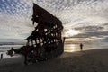 Boy stands by Peter Iredale shipwreck.