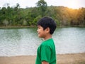 A boy stands by the reservoir in the evening. It shows looking at the goals in life