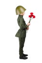 Boy stands sideways in military uniform and helmet, with carnations in hands