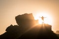 A boy stands on the top of a rock in at sunset Royalty Free Stock Photo