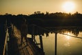 A boy stands on a wooden bridge at sunset Royalty Free Stock Photo