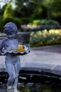 Boy statue with Day Lilly flower in the Garden. Royalty Free Stock Photo