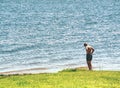 Boy stay in lake with water under knee and test temperature