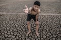 The boy stood bent on his knees and made a mark to ask for rain, global warming and water crisis Royalty Free Stock Photo