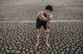 The boy stood bent on his knees and made a mark to ask for rain, global warming and water crisis Royalty Free Stock Photo