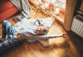 Boy stretching himself lying on floor on sheepskin and looking in window in cozy home atmosphere. Peaceful Lazy moments in cozy